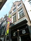 Pand met gevel met in- en uitgezwenkte top onder rollagen