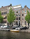 Pand met gevel met gebeeldhouwde kelderpui, gesneden deuromlijsting en ornament onder de middenvensters