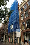 Huis van pakhuisachtig karakter, met puntgevel waarin geblokte bedrijfspui