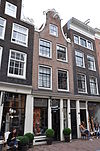 Huis met gepleisterde en van een vaag klokvormige top voorziene gevel