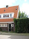 Blok met 8 keukenwoningen, zo genoemd vanwege destijds nieuwe plaatsing van keuken aan de voorzijde, aan de zijkant een houten topgevel, bouwstijl Amsterdamse School, samen met de poortgebouw langs de Purmerweg centraal deel van Tuindorp Nieuwendam