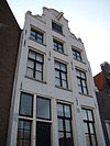 Pand met gepleisterde halsgevel met gedeelde vleugelstukken