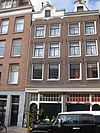 Huis met gevel onder in het midden cirkelvormig verhoogde lijst