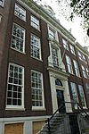 Dubbel huis met gevel, voorzien van middenrisaliet en hoeklisenen, onder rechte lijst en attiek
