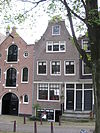 Huis waarvan de gevel wordt beëindigd door een klokvormige top onder rollagen