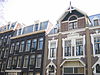 WLM - Minke Wagenaar - 126 2659 - Omschrijving rijksmonument Bakstenen remisedeel met de voorgevel aan de Schinkelhavenstraat 27 en de achtergevel aan de Eerste Schinkelhavenstraat 16. Aan de oostzijde grenst het gebouw aan het binnenterrein. De voorgevel geeft de onderverdeling van dit deel van het gebouw in drie bouwlagen weer: hoofdverdieping, verdieping en kapverdieping. Op de hoofdverdieping een brede toegangsdeur met luifel. Onder de overkapping van de luifel de initialen van de A.O.M. tussen florale decoratie. Ter rechte…