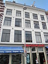 Twee huizen onder rechte lijst met consoles