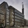 Overzicht bedrijfspand van de Telegraaf, voorgevel met hoge toren met beeldhouwwerk