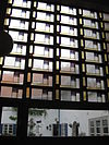 Greinerglas -  Glas-in-lood ramen van Brink 43, Amsterdam-Oost met de bejaardenwoningen erachter zichtbaar.