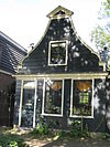 Houten dijkhuis met klokgevel (uit- en ingezwenkt voorschot) uit 19de eeuw