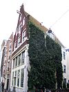 Huis met pilastergevel waarvan de pilasters gehalveerd en de top tot rollagenpunt is afgekloofd