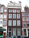 Huis met gevel onder gebeeldhouwde lijst en attiek en twee zandstenen schoorstenen op het dwarse dak