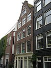 Huis met gevel onder klokvormige top met rollagen
