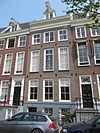 Huis, onderdeel van oud huizenblok met doorlopend dwars dak. Gevel onder rechte lijst waarop dakkapel