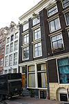Onderdeel van een drie huizen omvattend pand met lisenengevel onder rechte lijst en vensterfrontons