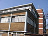 WLM - Minke Wagenaar - 124 2454 - Inleiding In 1938-1939 op de hoek van de Van Hallstraat en de Kostverlorenvaart gebouwd FABRIEKSGEBOUW met bovenwoningen, naar een ontwerp van B. Merkelbach en Ch.J.F. Karsten in de stijl van het Nieuwe Bouwen, in opdracht van de Drukinktfabriek Gebr. Hartmann's Graficolor N.V. De hoofdaannemer was Fa. Boele & van Eesteren. De stalen ramen werden geleverd door De Vries RobbÃ© & Co. Gedenksteen ter gelegenheid van eerstesteenlegging: zaterdag 25 maart 1939. NB. In 1941 is de schoorsteen …