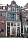 Huis met latere gevel onder klokvormige top met rollagen