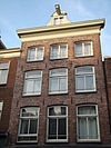 Huis met gevel onder klokvormige top met rollagen