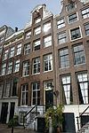 Pand met halsgevel met vleugelstukken van bijzonder ontwerp en met drie karikatuurkoppen