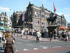 Rokin Langebrugsteeg 2 -  Intersection of Langebrugsteeg and Rokin in Amsterdam. Tourists are waiting to get on board a canal excursion boat. Note the equestrian statue of Queen Wilhelmina and the Allard Pierson Museum on the right.  Amsterdam - Turfdraagsterpad 15. Tussen Grimburgwal, Binnengasthuisstraat en Turfdraagsterpad in 1874-77 naar eclectisch ontwerp van A.N. Godefroy en B. de Greef opgetrokken gebouw, in oorsprong bestemd als VROUWENVERBAND, in opdracht van de regenten van het Binnen- en Buitengasthuis. Het …