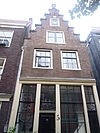 Huis met eenvoudige trapgevel op houten pui