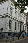 Dubbel hoekpand, gebouwd in 1685, geheel verbouwd in 1860/61 door cornelis outshoorn, met van rijke stucversieringen voorziene gepleisterde gevels onder bewerkte lijst, en zandstenen pui met balcon