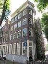 Hoekhuis met gevel met afgeschuinde hoektravee en rechte omlopende lijst