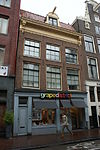 Twee huizen achter gemeenschappelijke gevel onder rechte lijst met consoles