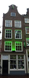 Hoekhuis waarvan de voorgevel zijn top heeft verloren en van een provisorische afsluiting is voorzien