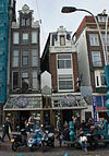 Pand met halsgevel met rijk gebeeldhouwde gedeelde vleugelstukken en gelobde volutenafdekking waarin ornament