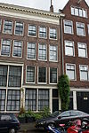 Huis met gevel onder rechte klossenlijst waarboven een bakstenen topje
