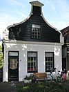 Houten dijkhuis met klokgevel (uit- en ingezwenkt voorschot)