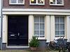 Pand met gevel onder gesneden rechte lijst met consoles waarboven een schilddakje