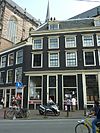 Pand onder schilddak tegen de nieuwe kerk met een vleugelstukje aan het linkeruiteinde van de gevel