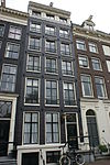 Pand met gevel onder rijk gesneden rechte lijst, met deurpartij