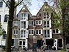 Pakhuis met gave puntgevel waarin tweelichten onder bogen, windkast, toppilaster en op de scheiding met nr 18 waarmee dit pand een groep vormt, een jaartalsteen en een steen met schottenbvrch