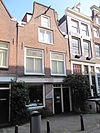 Huis met latere gevel onder klokvormige geveltop met rollagen