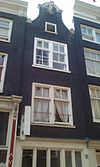 Zeedijk 88, Amsterdam -  Huis, vanwege de 18e-eeuwse aanzetkrullen en afdekking van de klokvormige geveltop 