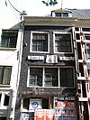 Hoekhuis onder schilddak, met jaartallinten en gevelsteen