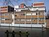 WLM - Minke Wagenaar - 124 2457 - Inleiding In 1938-1939 op de hoek van de Van Hallstraat en de Kostverlorenvaart gebouwd FABRIEKSGEBOUW met bovenwoningen, naar een ontwerp van B. Merkelbach en Ch.J.F. Karsten in de stijl van het Nieuwe Bouwen, in opdracht van de Drukinktfabriek Gebr. Hartmann's Graficolor N.V. De hoofdaannemer was Fa. Boele & van Eesteren. De stalen ramen werden geleverd door De Vries RobbÃ© & Co. Gedenksteen ter gelegenheid van eerstesteenlegging: zaterdag 25 maart 1939. NB. In 1941 is de schoorsteen …