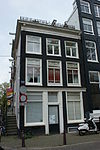 Hoekhuis met voorgevel onder rechte lijst met consoles en zijstoep met leuning