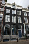 Huis met gevel onder verhoogde lijst met consoles