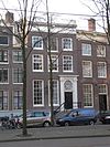 Pand met gevel onder rechte lijst met attiek, met fraaie deuromlijsting en snijraam