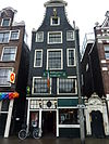 Vrijstaand huis met ingezwenkte halsgevel onder siertrossen