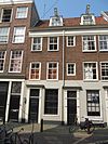 Complex beneden- en bovenwoningen met gevel onder rechte lijst en drie deuromlijstingen