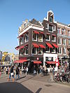 Hoekhuis onder schilddak, met omlopende lijst waarin consoles