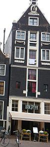 Huis van pakhuiskarakter, met puntgevel waarin festoenen, oeils-de-boeuf en jaartellingen