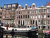 Pand met halsgevel met gedeelde vleugelstukken en ornament in de afdekking