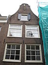Huis met gevel onder klokvormige top met rollagen