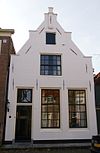 Pand met gepleisterde topgevel met toppilaster en treden ter halverhoogte